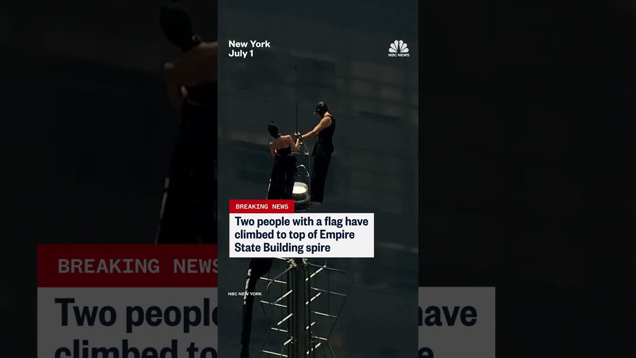 Two people climb the Empire State Building spire