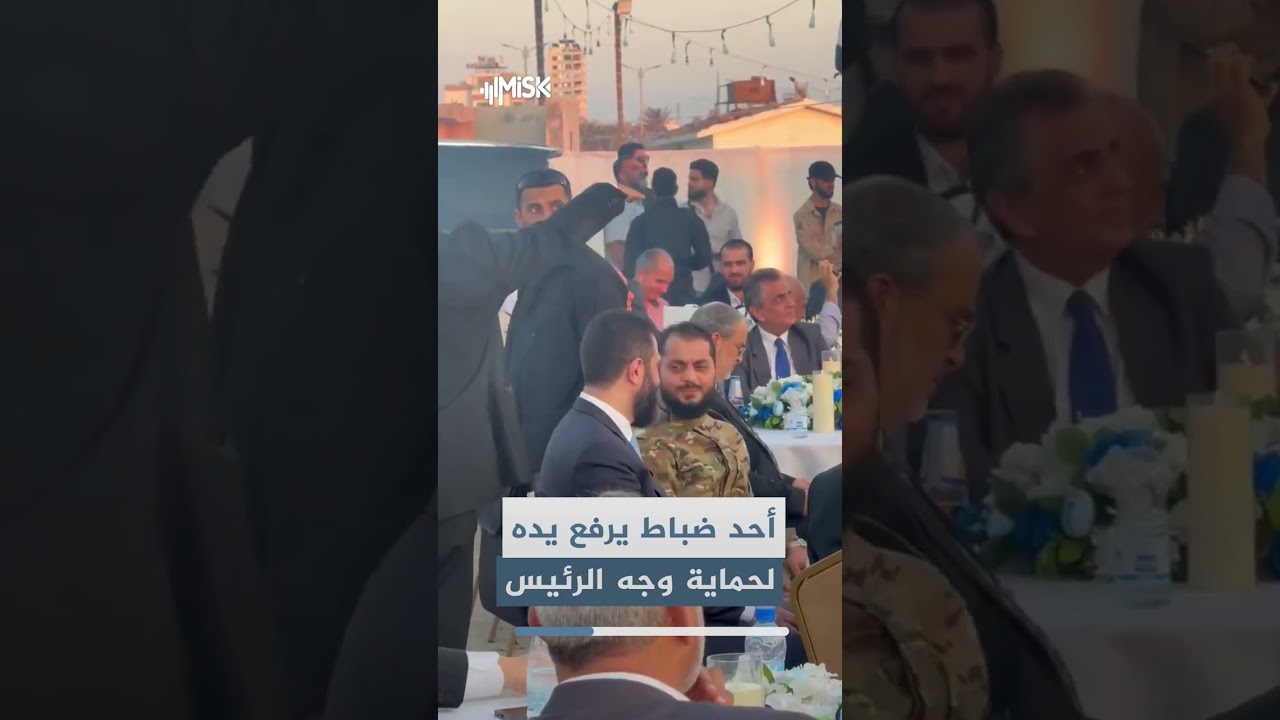 أحد ضباط وزارة الدفاع يرفع يده خوفاً على وجه الرئيس السوري أحمد الشرع أثناء زيارته لمحافظة طرطوس
