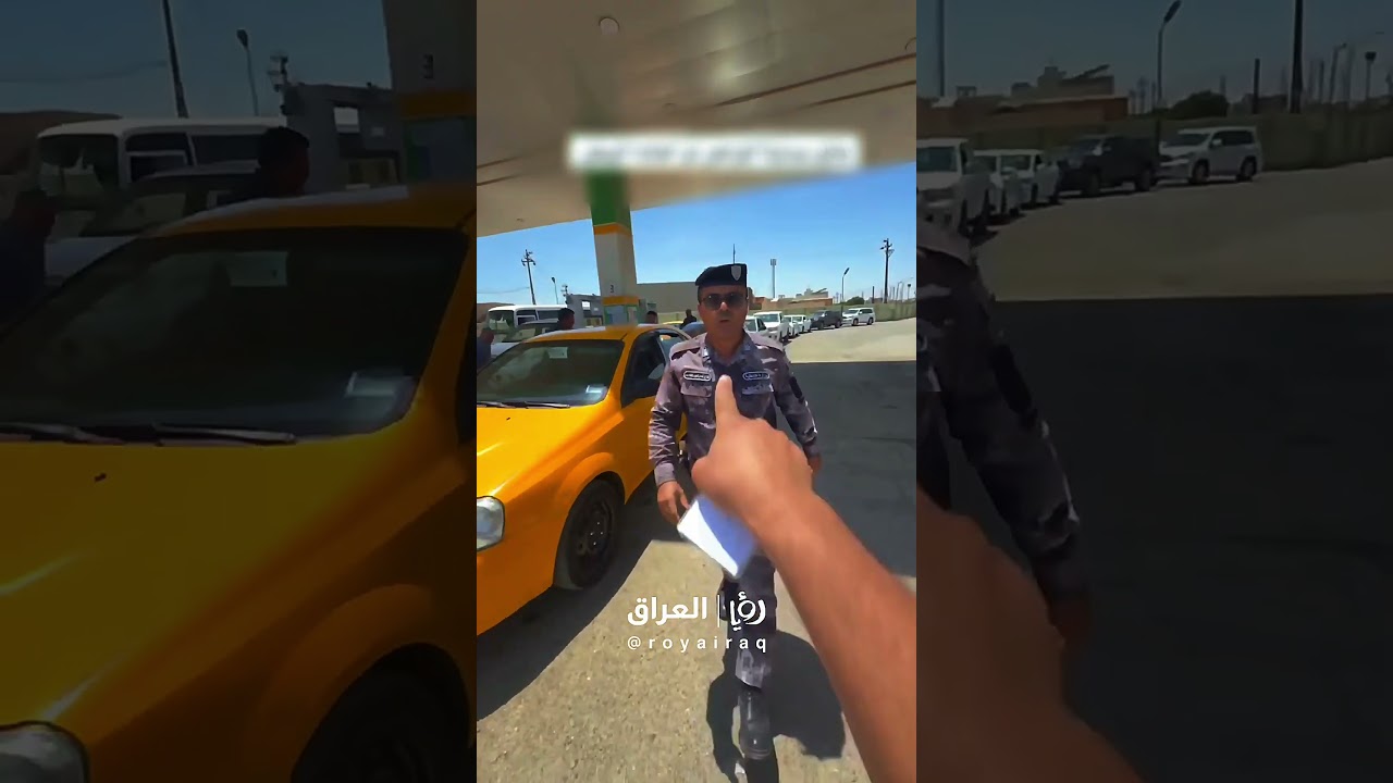 منتسب أمني في محطة الشورجة بمحافظة كركوك وهو يمنع أحد المواطنين من التصوير